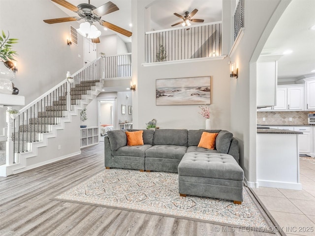 12411 E 90th St N, Owasso, OK 74055 - living room with ceiling fan, stairway, a towering ceiling, light wood finished floors, and recessed lighting