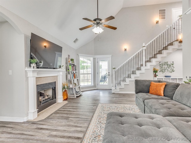 12411 E 90th St N, Owasso, OK 74055 - living room with stairs, wood finished floors, ceiling fan, a fireplace with flush hearth, and high vaulted ceiling