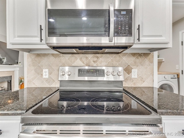 12411 E 90th St N, Owasso, OK 74055 - kitchen with appliances with stainless steel finishes, washer / dryer, white cabinets, and tasteful backsplash