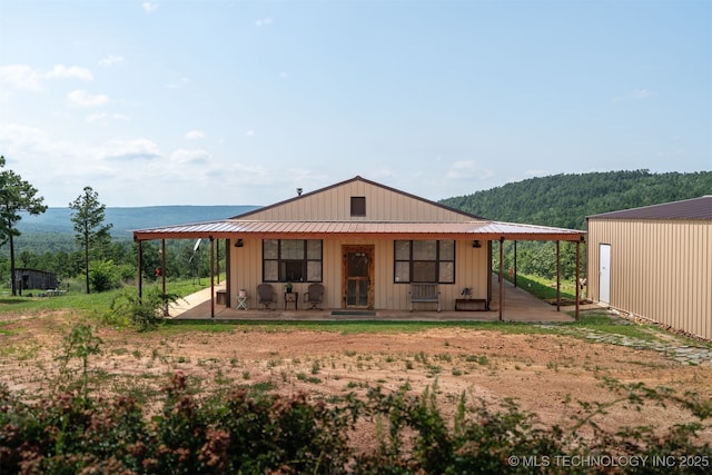 3819 129th Rd, Panola, OK 74559 - view of front of home featuring board and batten siding, a mountain view, and an outdoor structure