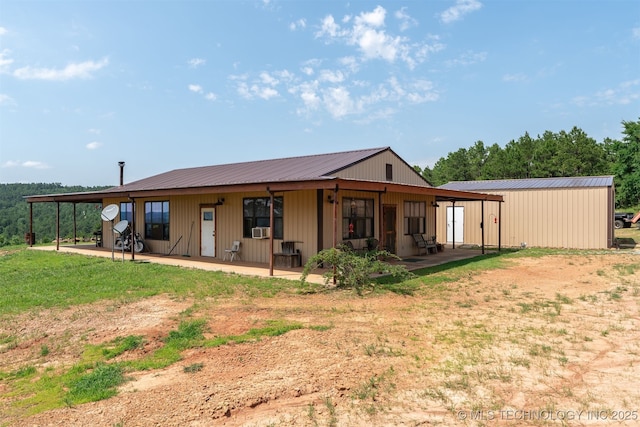 3819 129th Rd, Panola, OK 74559 - back of property featuring metal roof, cooling unit, and a patio