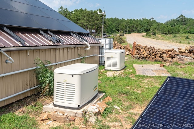 3819 129th Rd, Panola, OK 74559 - exterior view of a power unit, metal roof, and a heavily wooded area