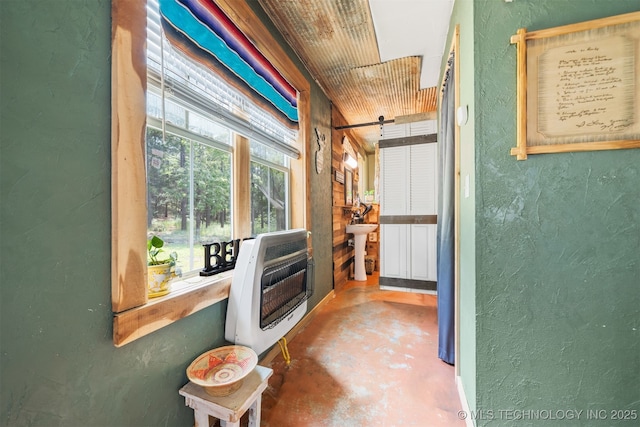 3819 129th Rd, Panola, OK 74559 - corridor featuring a textured wall, heating unit, concrete flooring, and a sink