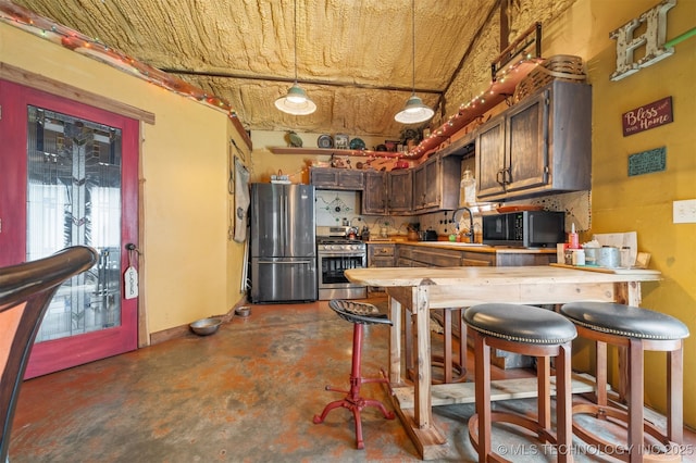 3819 129th Rd, Panola, OK 74559 - kitchen featuring stainless steel appliances, concrete flooring, a sink, a peninsula, and decorative light fixtures