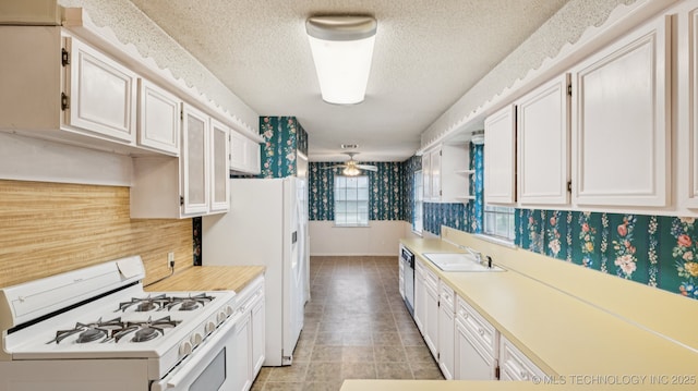 22112 W Coyote Trl Unit S, Sand Springs, OK 74063 - kitchen featuring white appliances, a sink, wallpapered walls, light countertops, and a textured ceiling