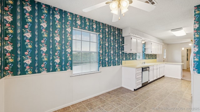 22112 W Coyote Trl Unit S, Sand Springs, OK 74063 - kitchen featuring wainscoting, white dishwasher, wallpapered walls, ceiling fan, and light countertops