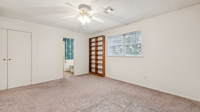 22112 W Coyote Trl Unit S, Sand Springs, OK 74063 - unfurnished bedroom with carpet, a closet, a textured ceiling, ensuite bath, and a ceiling fan