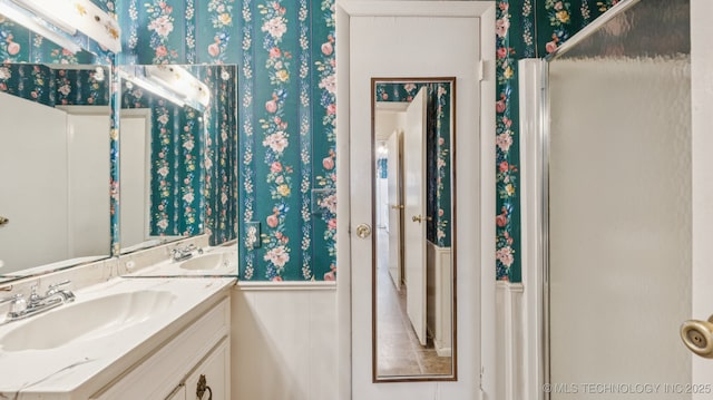 22112 W Coyote Trl Unit S, Sand Springs, OK 74063 - bathroom featuring wallpapered walls, double vanity, and wainscoting