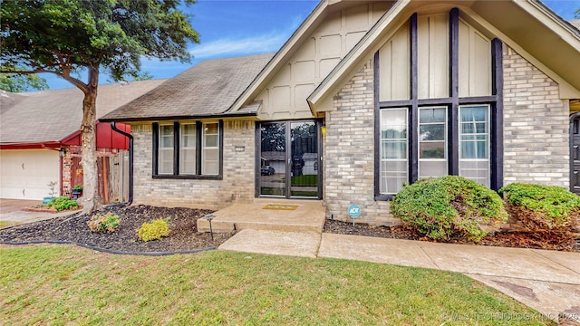 1120 N Juniper Pl, Broken Arrow, OK 74012 - view of front of home featuring brick siding, a front lawn, a garage, a shingled roof, and board and batten siding