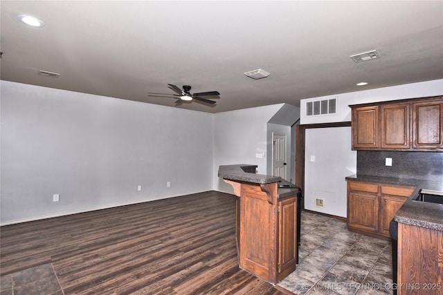307 W K St, Jenks, OK 74037 - kitchen featuring dark countertops, ceiling fan, recessed lighting, a breakfast bar area, and dark wood-style flooring
