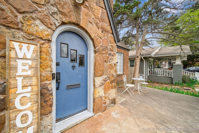 2124 E 19th St, Tulsa, OK 74104 - doorway to property with stone siding and a porch