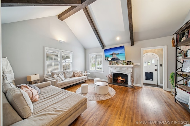 2124 E 19th St, Tulsa, OK 74104 - living area with a warm lit fireplace, beam ceiling, wood finished floors, baseboards, and high vaulted ceiling