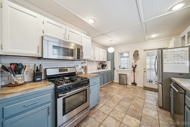 2124 E 19th St, Tulsa, OK 74104 - kitchen with appliances with stainless steel finishes, blue cabinets, white cabinets, light countertops, and backsplash