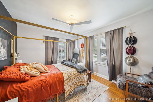 2124 E 19th St, Tulsa, OK 74104 - bedroom with multiple windows, wood finished floors, baseboards, and ceiling fan
