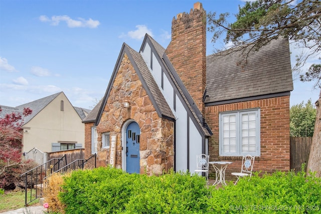 2124 E 19th St, Tulsa, OK 74104 - view of front of house featuring a shingled roof, a chimney, stone siding, and stucco siding