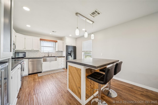 31102 S 4190th Rd, Inola, OK 74036 - kitchen featuring black appliances, dark countertops, a sink, tasteful backsplash, and white cabinetry
