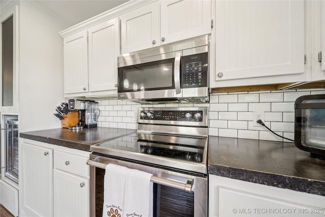 31102 S 4190th Rd, Inola, OK 74036 - kitchen featuring stainless steel appliances, backsplash, dark countertops, and white cabinetry