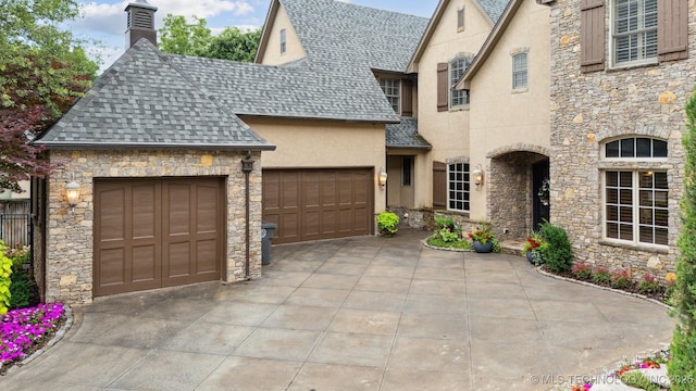 5912 E 119th St, Tulsa, OK 74137 - french country home with stone siding, a shingled roof, stucco siding, an attached garage, and a chimney