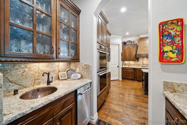 5912 E 119th St, Tulsa, OK 74137 - kitchen featuring appliances with stainless steel finishes, a sink, arched walkways, decorative backsplash, and glass insert cabinets