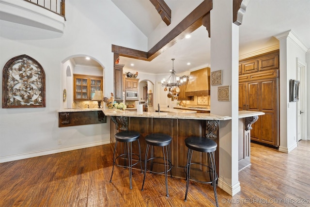 5912 E 119th St, Tulsa, OK 74137 - bar featuring stainless steel microwave, custom exhaust hood, wood finished floors, a sink, and baseboards