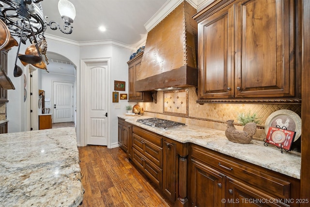 5912 E 119th St, Tulsa, OK 74137 - kitchen featuring custom range hood, stainless steel gas cooktop, arched walkways, dark wood-type flooring, and tasteful backsplash