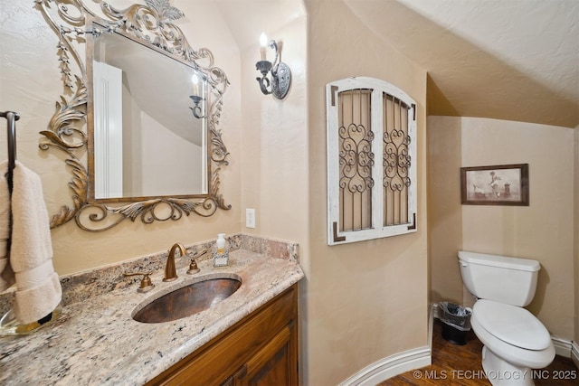 5912 E 119th St, Tulsa, OK 74137 - half bath with toilet, vanity, vaulted ceiling, baseboards, and wood finished floors