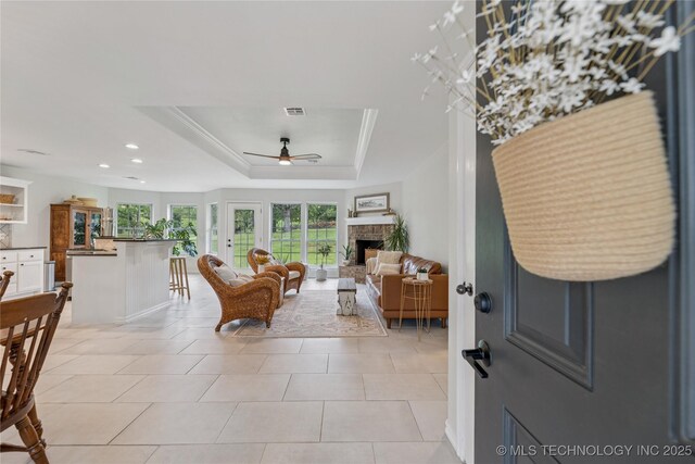 11587 W 86th St S, Sapulpa, OK 74066 - living room featuring a ceiling fan, a fireplace, a tray ceiling, recessed lighting, and light tile patterned floors