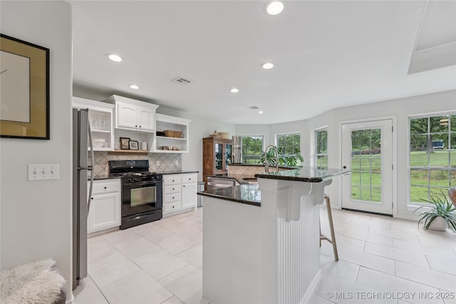11587 W 86th St S, Sapulpa, OK 74066 - kitchen with black gas stove, open shelves, backsplash, white cabinets, and light tile patterned flooring