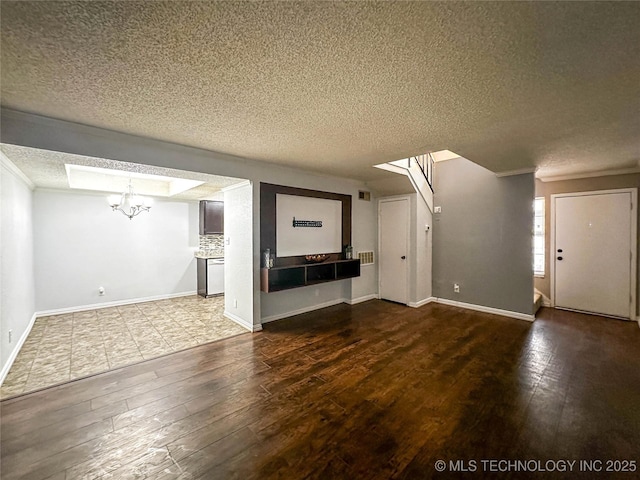 2213 E 67th St Unit 1405, Tulsa, OK 74136 - unfurnished living room featuring a textured ceiling, a chandelier, hardwood / wood-style floors, crown molding, and baseboards