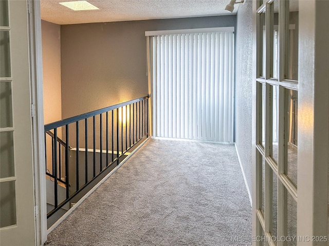 2213 E 67th St Unit 1405, Tulsa, OK 74136 - hallway featuring carpet flooring, a textured ceiling, and a textured wall