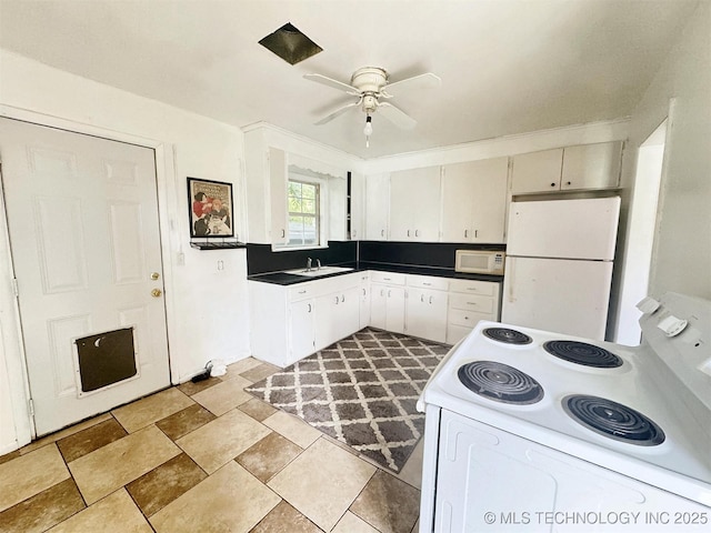 226 W Seneca St, Tahlequah, OK 74464 - kitchen featuring white appliances, a ceiling fan, dark countertops, light stone finish floors, and a sink