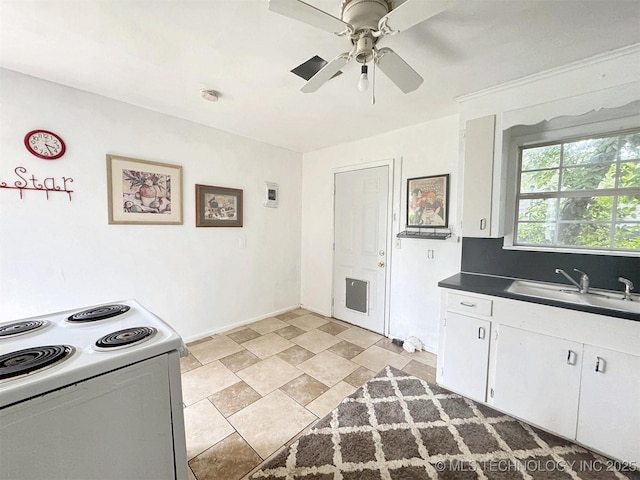 226 W Seneca St, Tahlequah, OK 74464 - kitchen with white electric range, a sink, dark countertops, a ceiling fan, and white cabinets