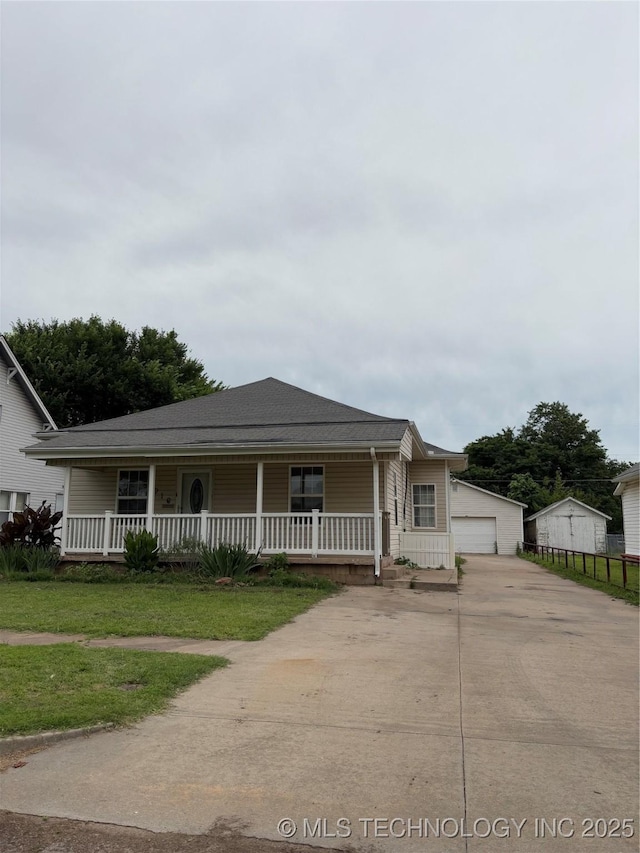 910 E Maple St, Cushing, OK 74023 - view of front facade with covered porch, a front yard, and roof with shingles