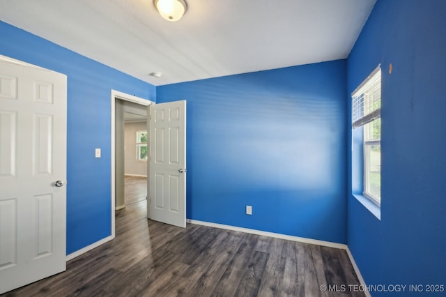 4126 E 36th Pl, Tulsa, OK 74135 - unfurnished bedroom with multiple windows, dark wood-style flooring, and baseboards