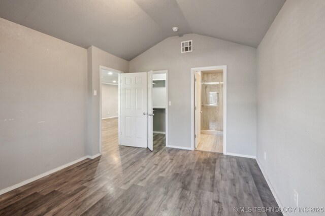 4126 E 36th Pl, Tulsa, OK 74135 - unfurnished bedroom featuring lofted ceiling, wood finished floors, connected bathroom, a walk in closet, and baseboards