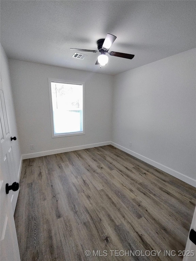 1400 NE 3rd St, Pryor, OK 74361 - spare room featuring wood finished floors, a textured ceiling, baseboards, and ceiling fan