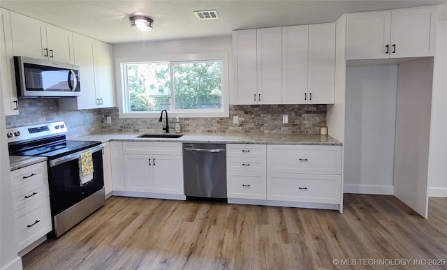 1400 NE 3rd St, Pryor, OK 74361 - kitchen featuring stainless steel appliances, a sink, light wood-type flooring, and tasteful backsplash
