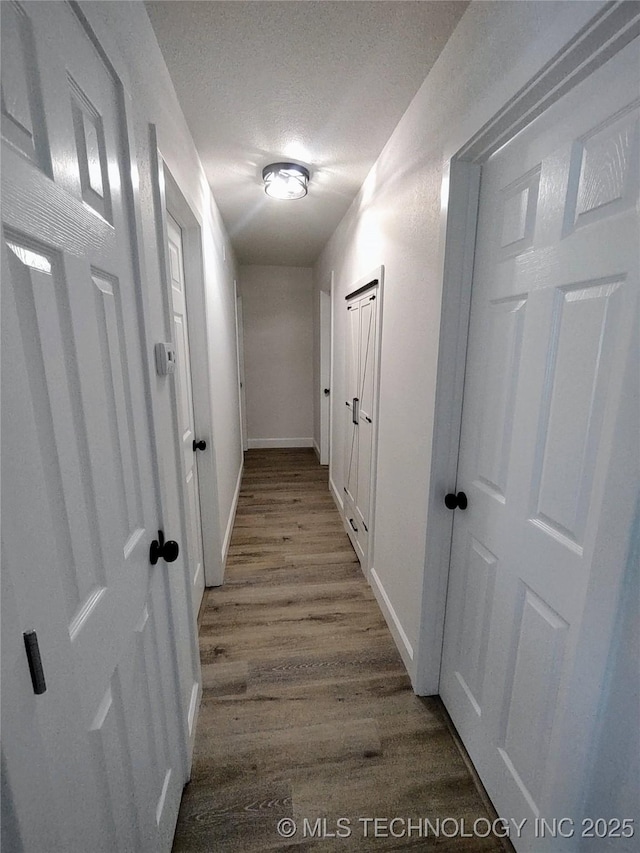 1400 NE 3rd St, Pryor, OK 74361 - hall with wood finished floors, baseboards, and a textured ceiling