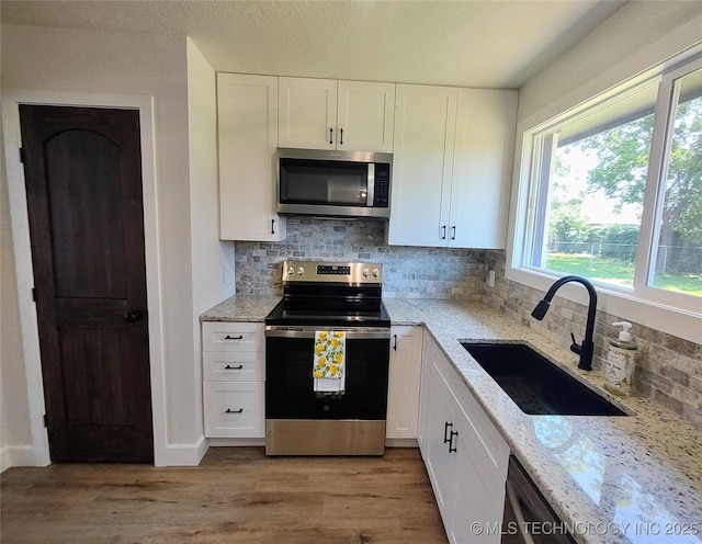 1400 NE 3rd St, Pryor, OK 74361 - kitchen with appliances with stainless steel finishes, a sink, light stone countertops, and white cabinets