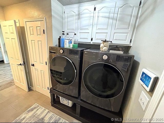 3109 Buffalo Ln, Grove, OK 74344 - washroom featuring washing machine and clothes dryer, light tile patterned floors, cabinet space, and a textured wall