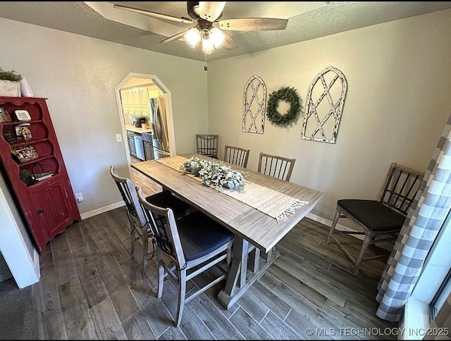 3109 Buffalo Ln, Grove, OK 74344 - dining room with dark wood-style floors, a ceiling fan, arched walkways, and baseboards