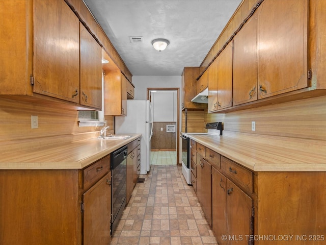 1921 S Santa Fe Pl, Bartlesville, OK 74003 - kitchen with white appliances, under cabinet range hood, light countertops, and brown cabinets