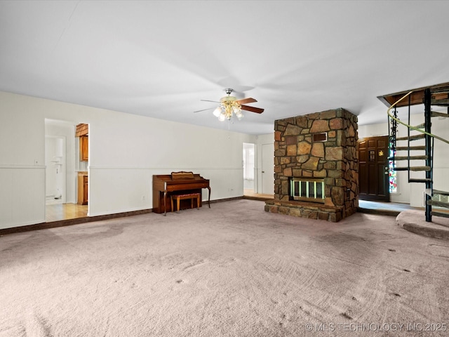512 W 20th, Bartlesville, OK 74003 - unfurnished living room with carpet floors, a ceiling fan, stairs, and a stone fireplace