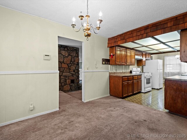 512 W 20th, Bartlesville, OK 74003 - kitchen with white appliances, a chandelier, a wainscoted wall, under cabinet range hood, and carpet floors