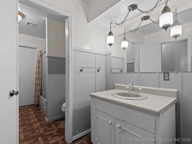 512 W 20th, Bartlesville, OK 74003 - bathroom with vanity, toilet, shower / tub combo with curtain, and wainscoting
