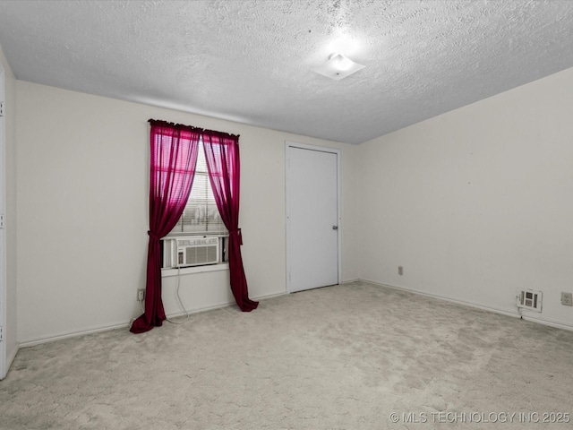 512 W 20th, Bartlesville, OK 74003 - carpeted spare room featuring cooling unit, a textured ceiling, and baseboards