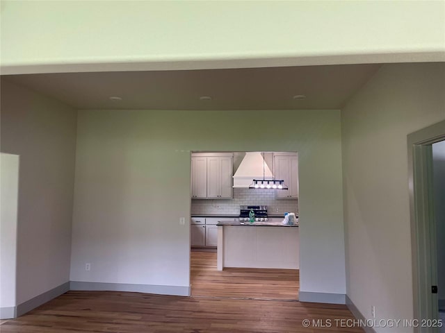 305 E Hickory Ave, Fort Gibson, OK 74434 - kitchen featuring stainless steel range, wood finished floors, backsplash, custom range hood, and dark countertops