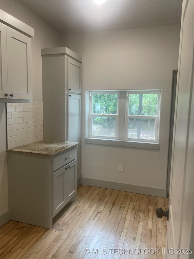 305 E Hickory Ave, Fort Gibson, OK 74434 - kitchen with light wood finished floors, backsplash, and baseboards