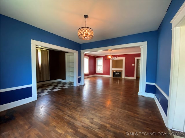 1501 E Okmulgee St, Muskogee, OK 74403 - unfurnished living room featuring a chandelier, baseboards, wood finished floors, and a fireplace