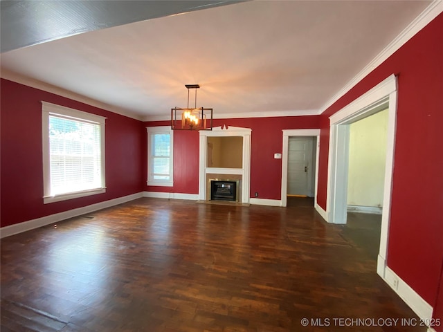 1501 E Okmulgee St, Muskogee, OK 74403 - unfurnished living room featuring a chandelier, baseboards, wood finished floors, crown molding, and a fireplace with flush hearth